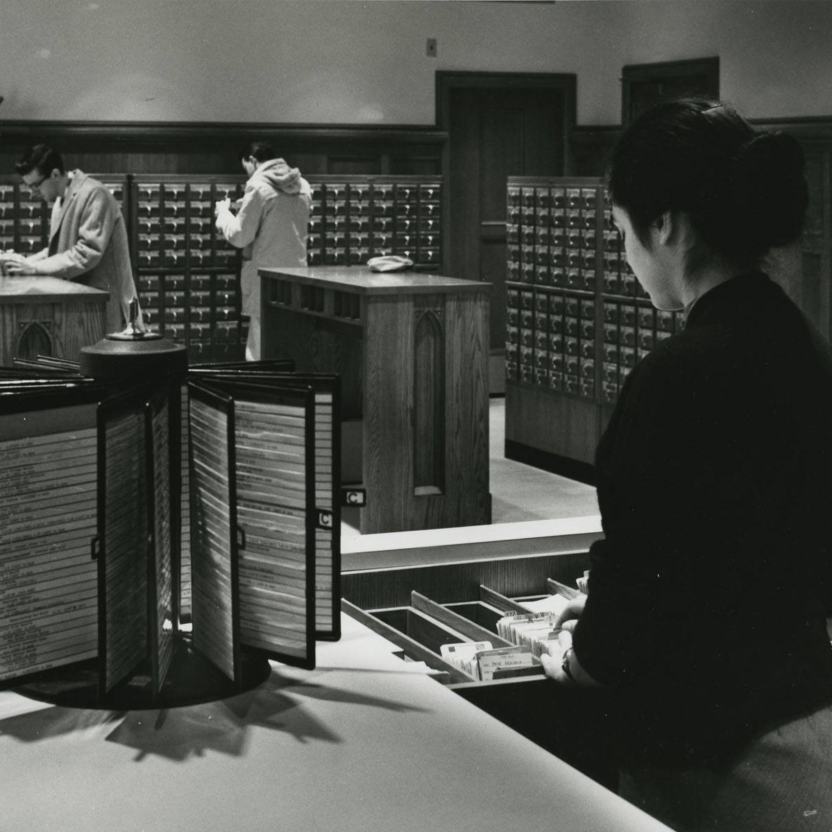 Archival photo of a person working at the circulation desk
