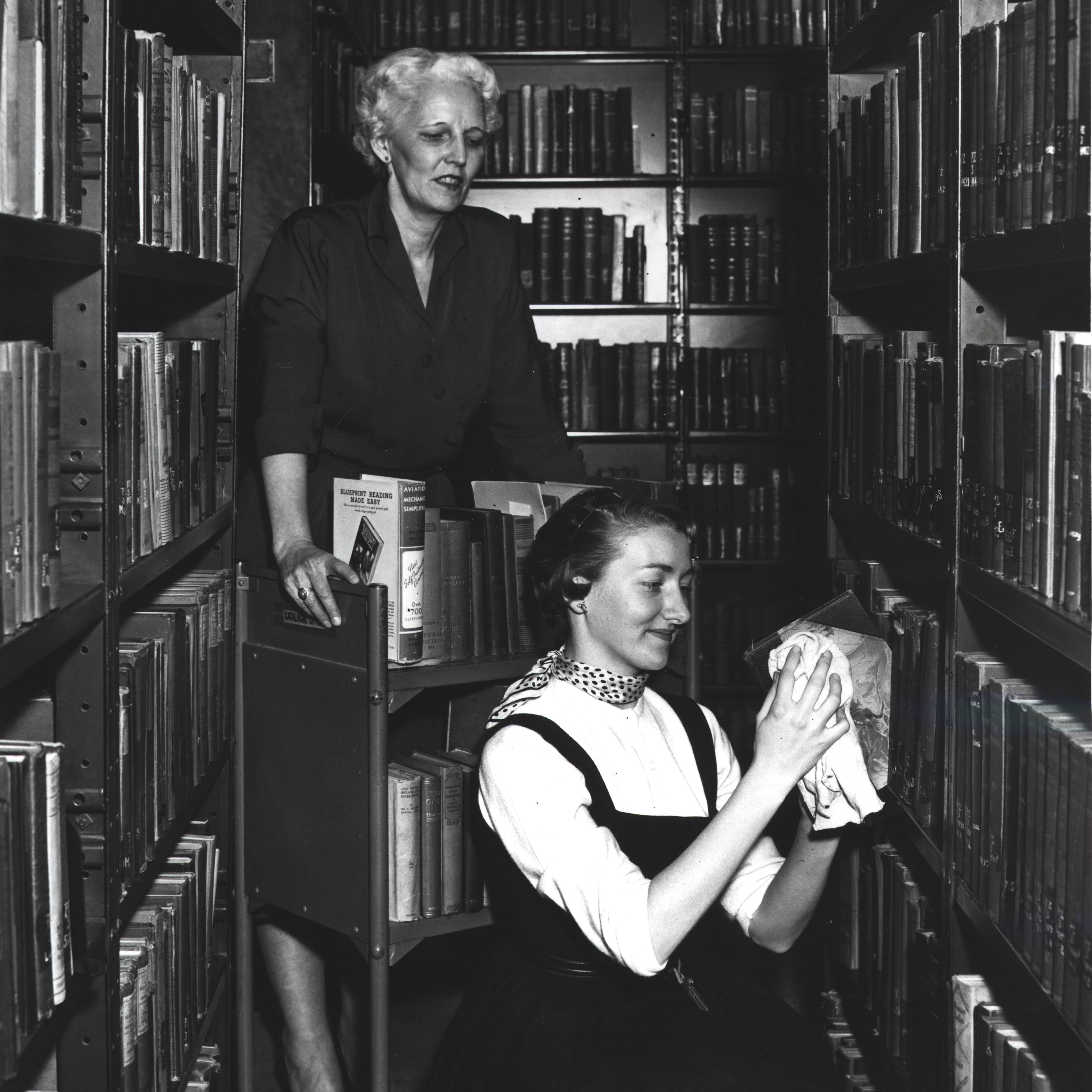 Archival photo of library staff putting away books
