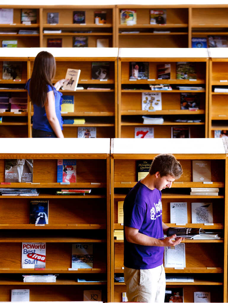 Students peruse library shelves and materials