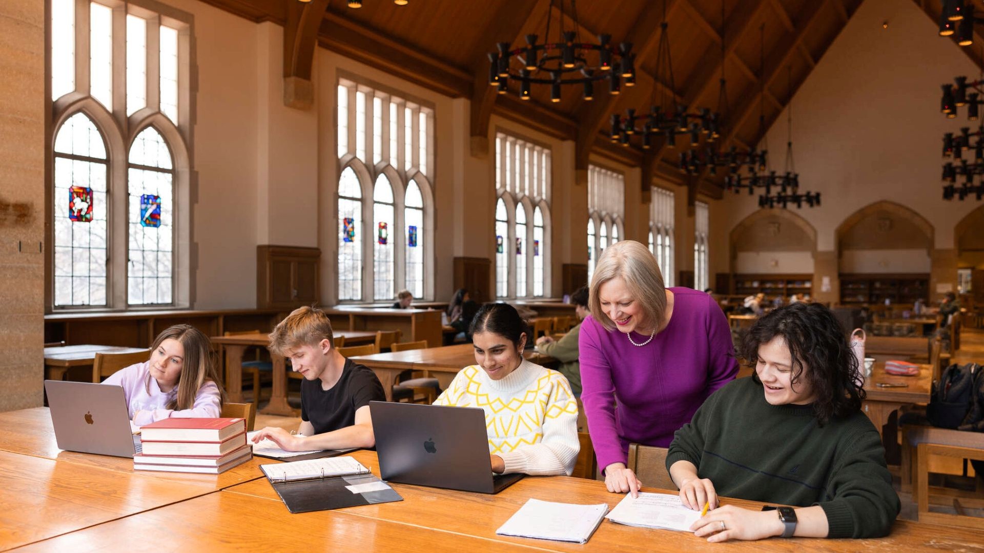 Students conversing with a university faculty member