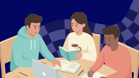 three students sit around a table working on school work 